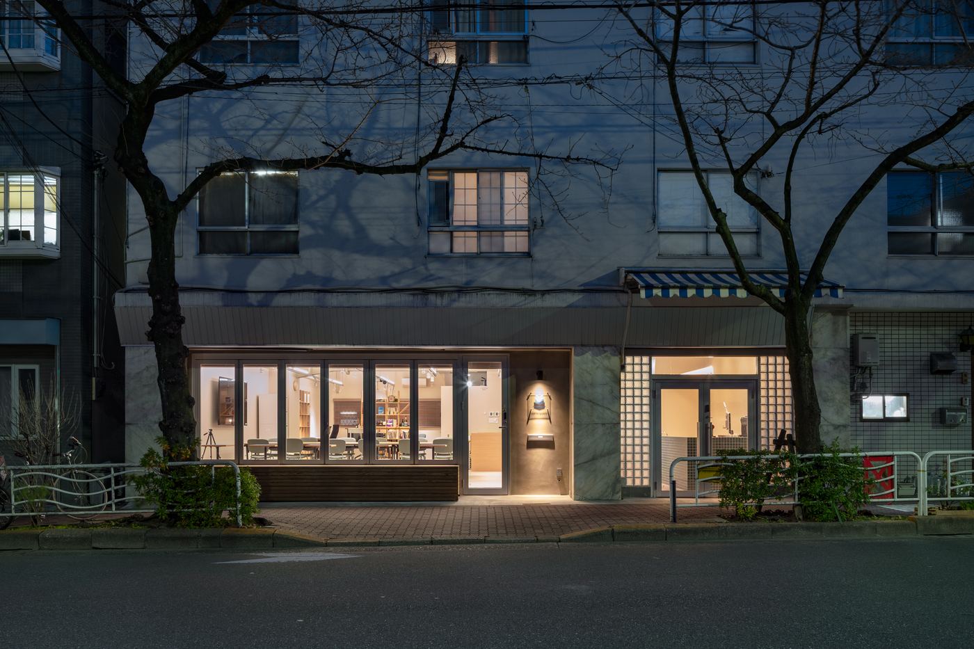 夜のnamespace外観。桜並木の通りに面したガラス張りの店舗